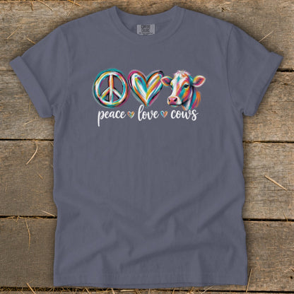 Blue-grey t-shirt featuring a colorful painted peace sign, heart, and cow graphic with the text peace love cows.