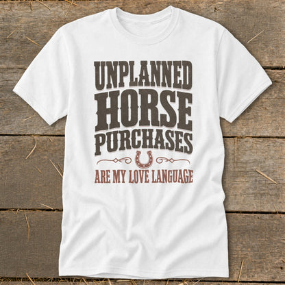 White t-shirt with text "UNPLANNED HORSE PURCHASES ARE MY LOVE LANGUAGE" and a horseshoe graphic.