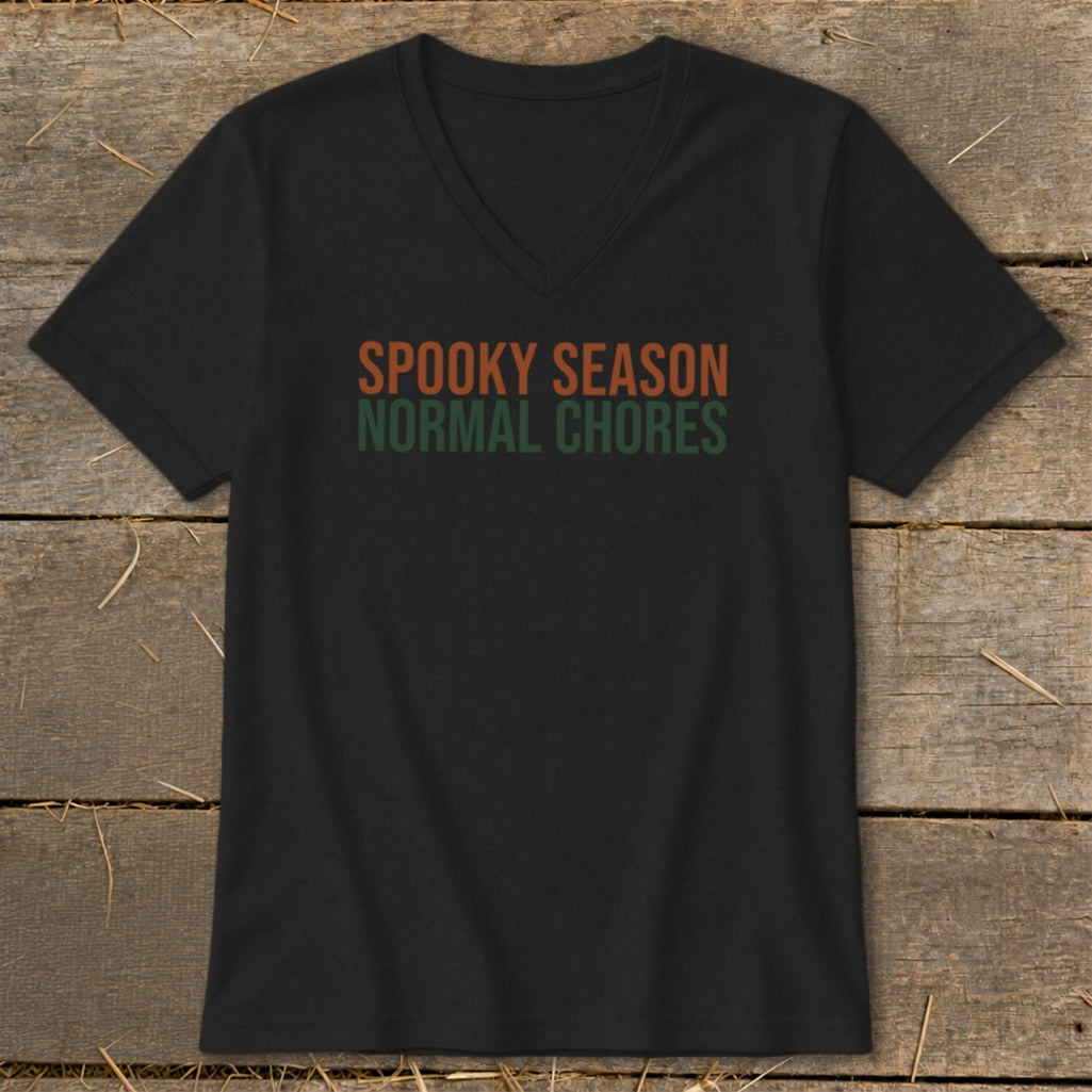 Black V-neck t-shirt with text "SPOOKY SEASON NORMAL CHORES" in orange and green.