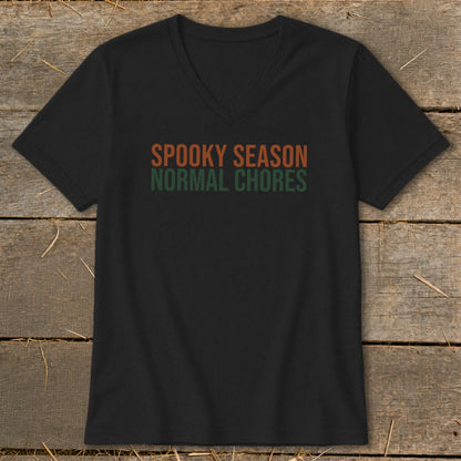 Black V-neck t-shirt with text "SPOOKY SEASON NORMAL CHORES" in orange and green.
