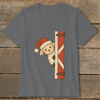 Sheep wearing a Santa hat peeking from behind a barn door.