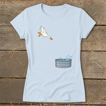 Light blue t-shirt with cartoon duck jumping into a galvanized water trough.
