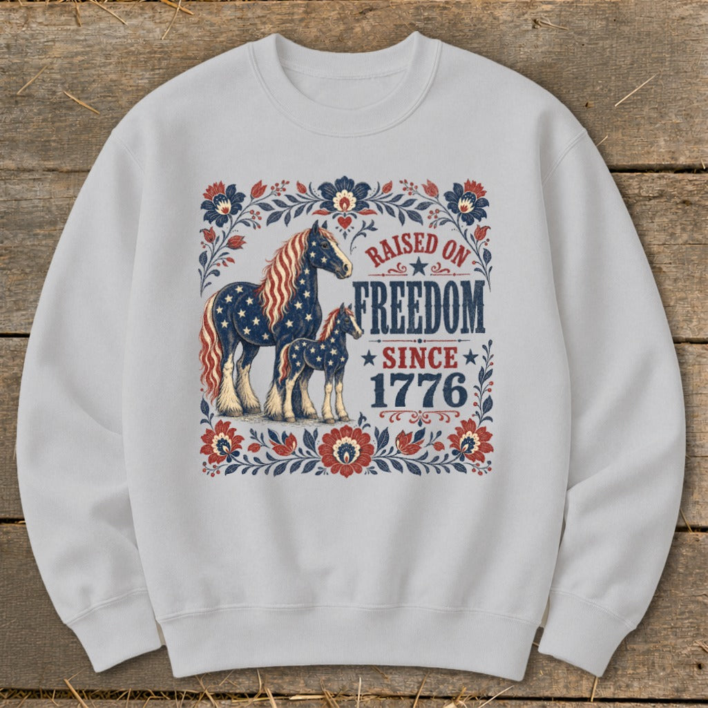 Adult and foal horses with American flag design, text "Raised on Freedom Since 1776".