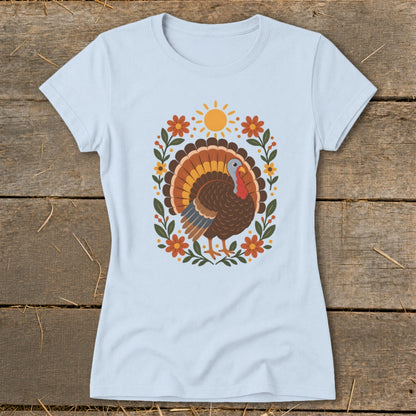 Light blue t-shirt with a Thanksgiving turkey illustration surrounded by flowers and sun.