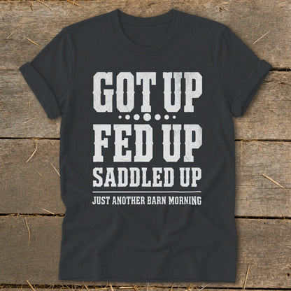 Dark gray t-shirt with white text: Got Up, Fed Up, Saddled Up, Just Another Barn Morning.