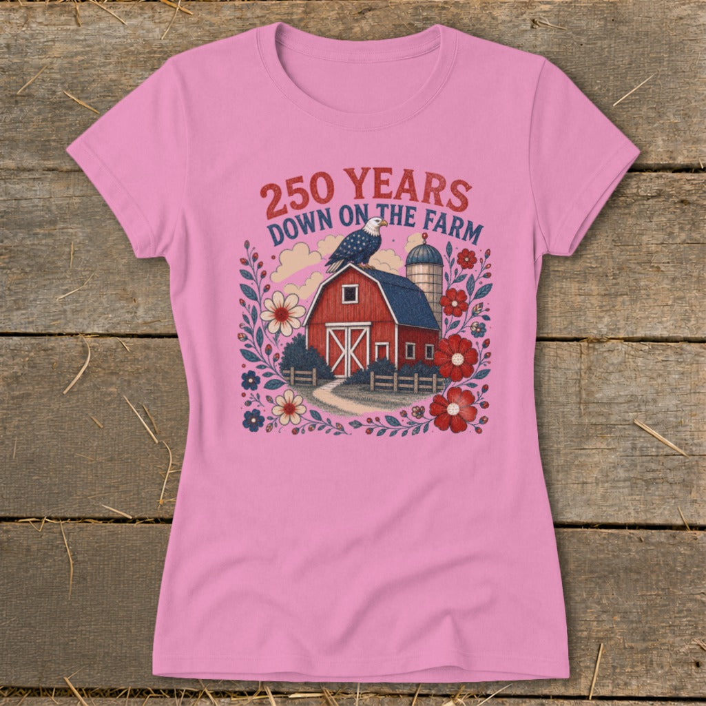 Pink t-shirt with a barn, eagle, and flowers design that says "250 Years Down on the Farm."