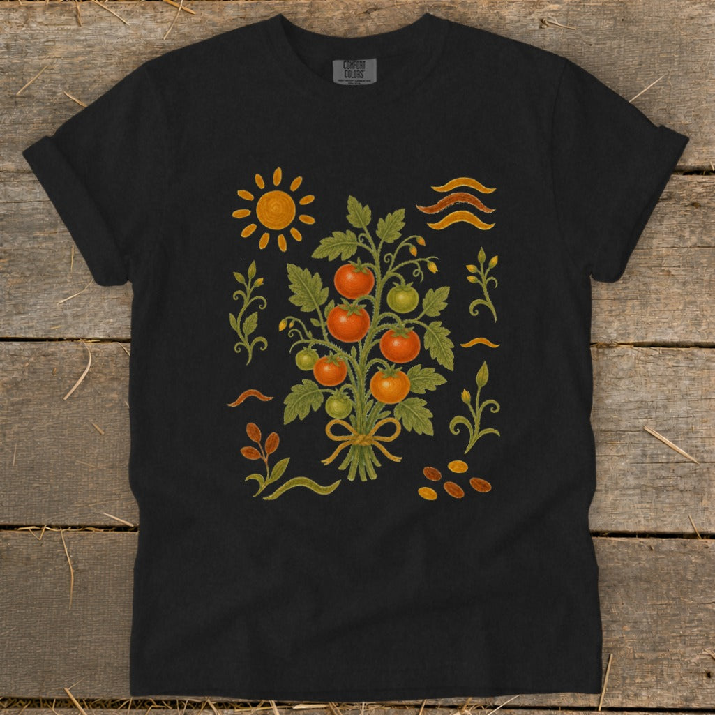 Black t-shirt with a folk art print of a tomato plant, sun, and wavy lines.