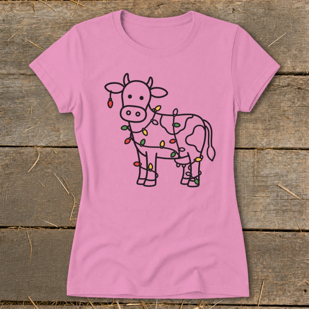 Pink t-shirt with a line drawing of a cow wrapped in colorful Christmas lights.