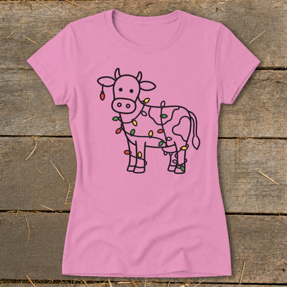Pink t-shirt with a line drawing of a cow wrapped in colorful Christmas lights.