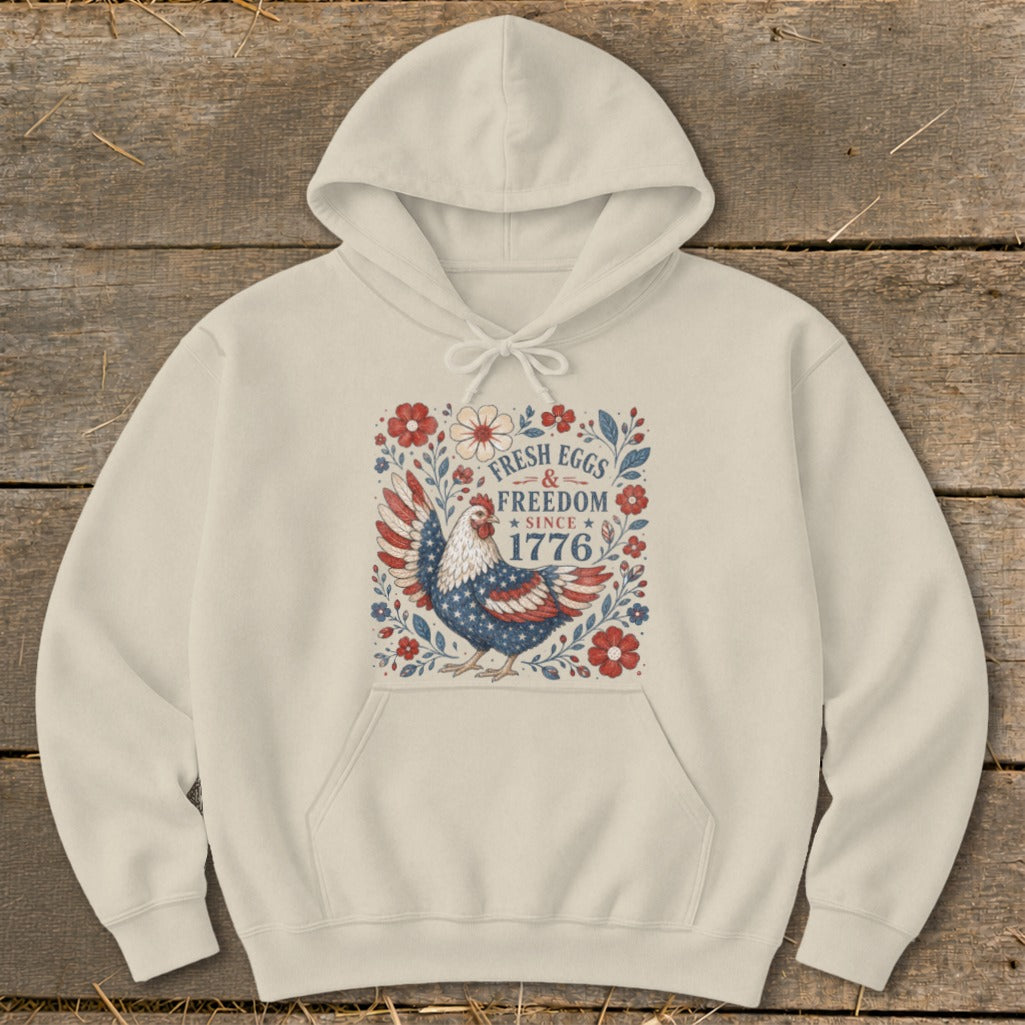 Cream hoodie with patriotic chicken and "Fresh Eggs & Freedom Since 1776" text.
