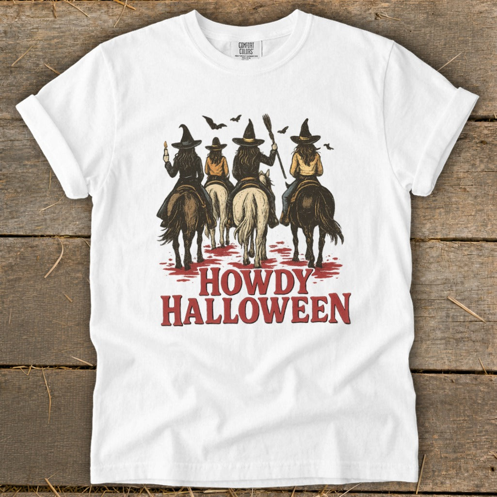 White t-shirt with witches on horses and "Howdy Halloween" text.