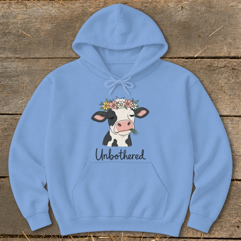 Light blue hoodie with a cow wearing a flower crown and text "Unbothered".