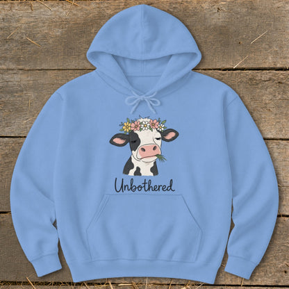 Light blue hoodie with a cow wearing a flower crown and text "Unbothered".