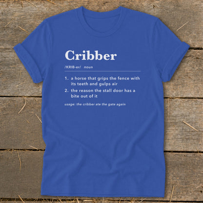 A royal blue t-shirt printed with a humorous dictionary-style definition of the word cribber.