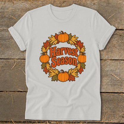 White t-shirt with "Harvest Season" text and pumpkin wreath graphic.