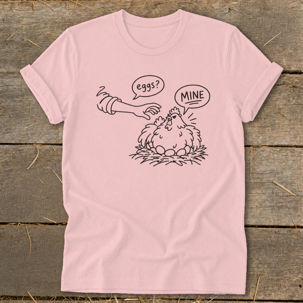 Pink t-shirt with cartoon chicken protecting eggs, saying "MINE".