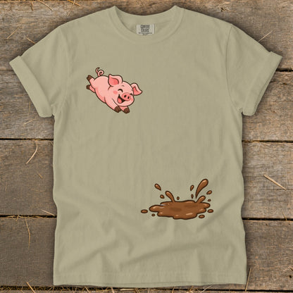 Tan t-shirt with cartoon pig jumping over a mud puddle graphic.