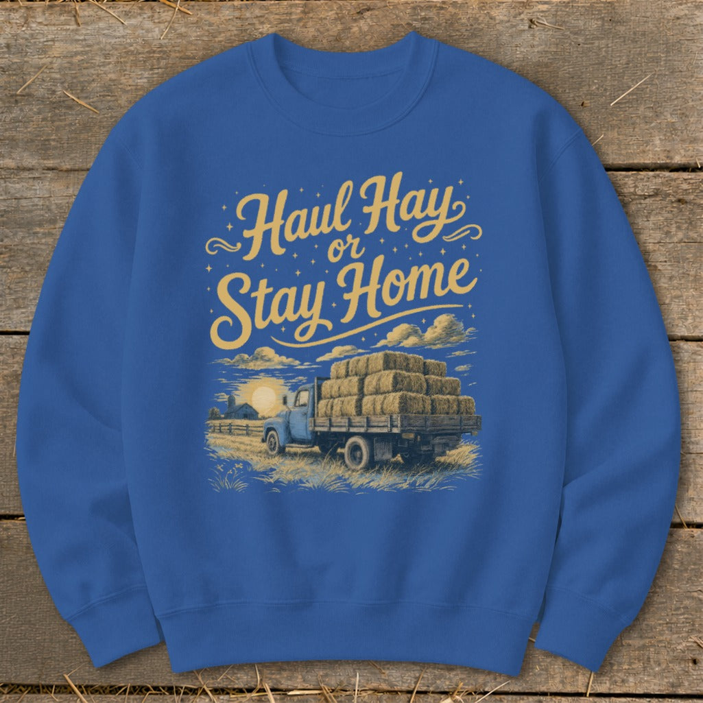 Blue sweatshirt with "Haul Hay or Stay Home" text and illustration of a truck loaded with hay bales.