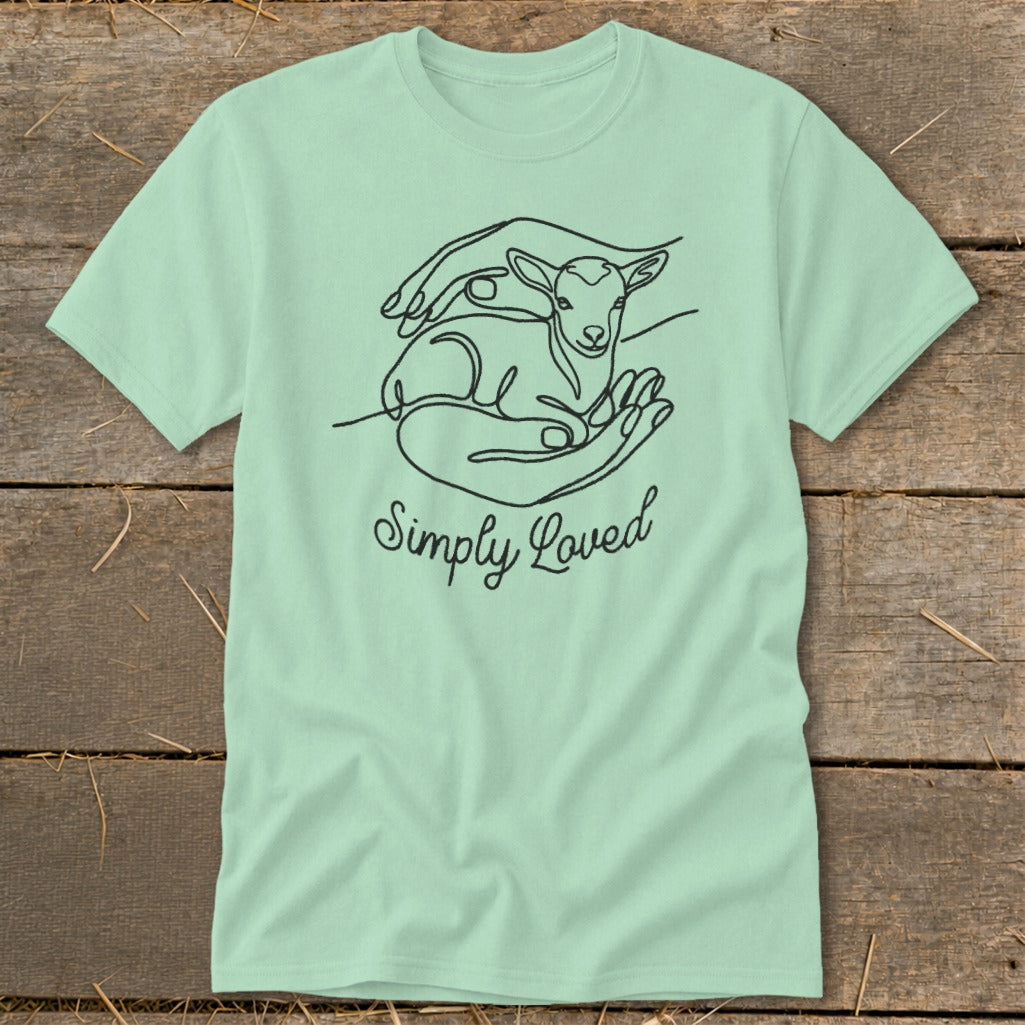 Light green t-shirt with a black line drawing of a lamb in hands and text "Simply Loved".