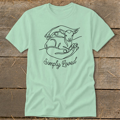 Light green t-shirt with a black line drawing of a lamb in hands and text "Simply Loved".