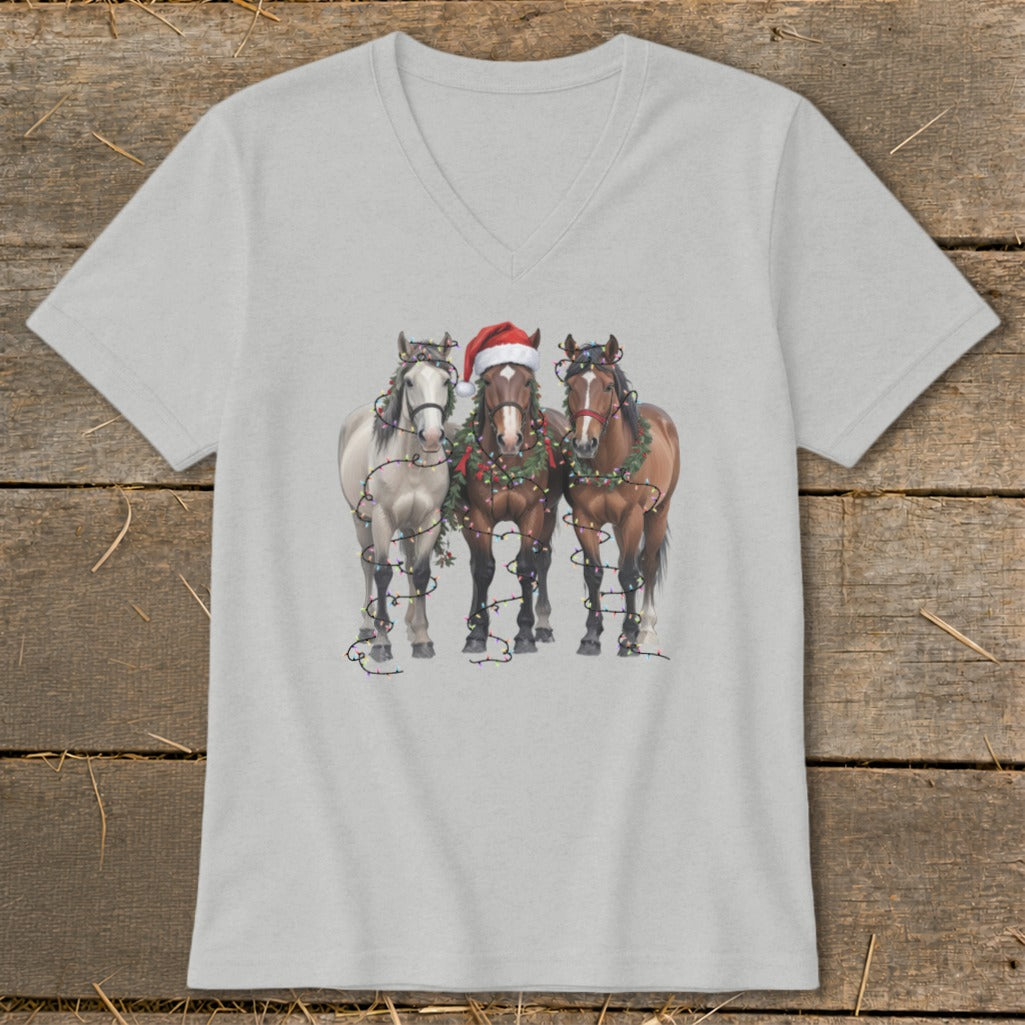 Three horses in Christmas decorations, including a Santa hat and lights.