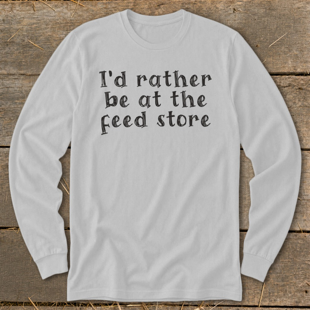 White long-sleeve shirt with black text reading "I'd rather be at the feed store."