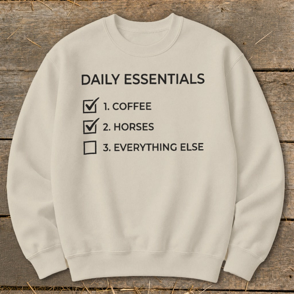 Cream sweatshirt with "Daily Essentials" and a checklist including coffee and horses.