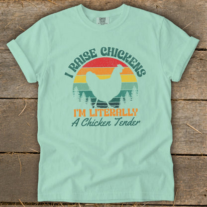Mint t-shirt with vintage sunset graphic and chicken silhouette. Text reads "I RAISE CHICKENS I'M LITERALLY A Chicken Tender".