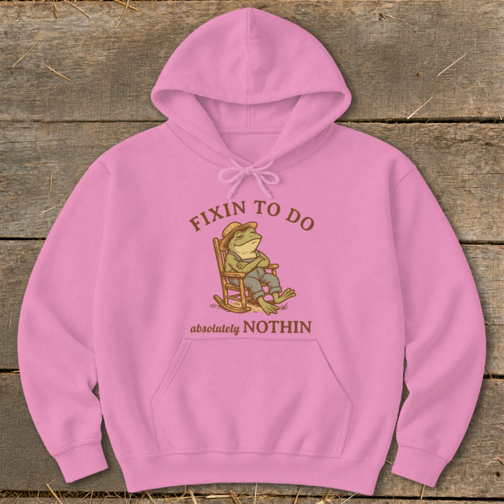 Pink hoodie with frog sitting in rocking chair, text "FIXIN TO DO absolutely NOTHIN".