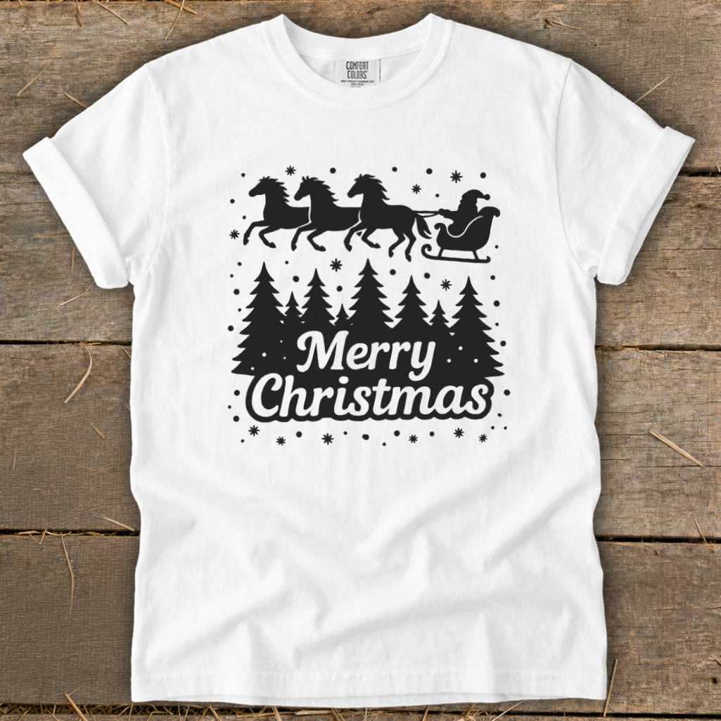 White t-shirt with black graphic of Santa's sleigh pulled by horses over pine trees and "Merry Christmas" text.