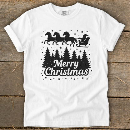 White t-shirt with black graphic of Santa's sleigh pulled by horses over pine trees and "Merry Christmas" text.