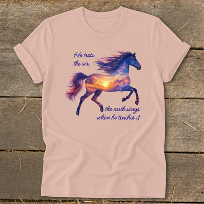 A pink t-shirt featuring a galloping horse graphic filled with a sunset sky and inspirational text.