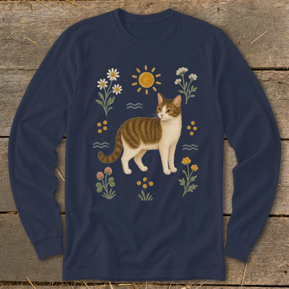Long-sleeved navy shirt with a tabby cat surrounded by wildflowers and a sun.