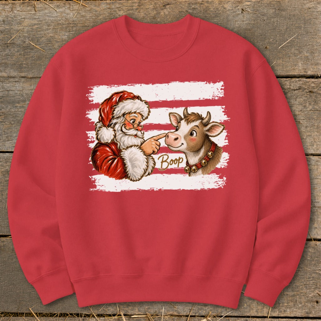 Santa booping a cow's nose with the word "Boop" on a red sweatshirt.