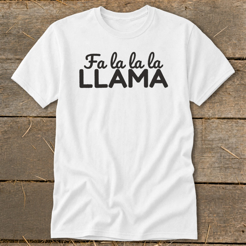 White t-shirt with black text "Fa la la la LLAMA" on a wooden background.