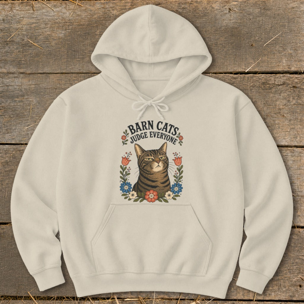 Cream hoodie with a graphic of a tabby cat surrounded by flowers and text reading "Barn Cats Judge Everyone".