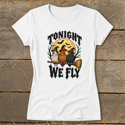 White t-shirt with three witch-hatted chickens on a broomstick and text "TONIGHT WE FLY".