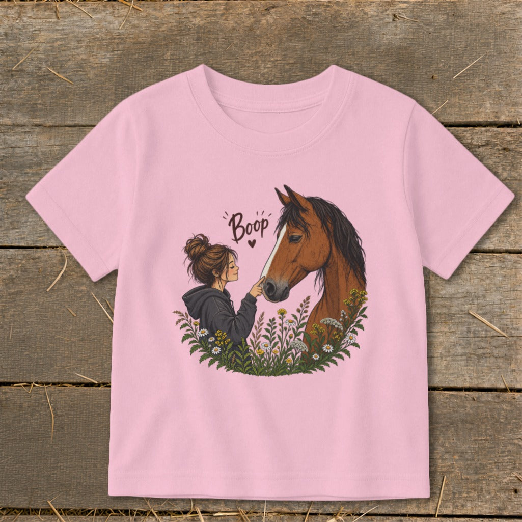 Pink t-shirt with illustration of girl booping a horse's nose amidst flowers.