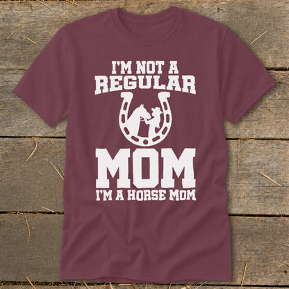 Maroon t-shirt with white text "I'M NOT A REGULAR MOM I'M A HORSE MOM" and horseshoe graphic.