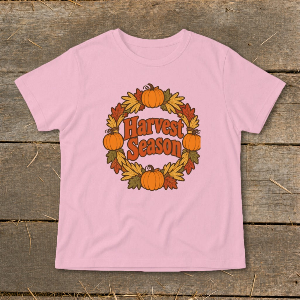Pink t-shirt with a floral wreath of pumpkins and leaves, featuring "Harvest Season" text.