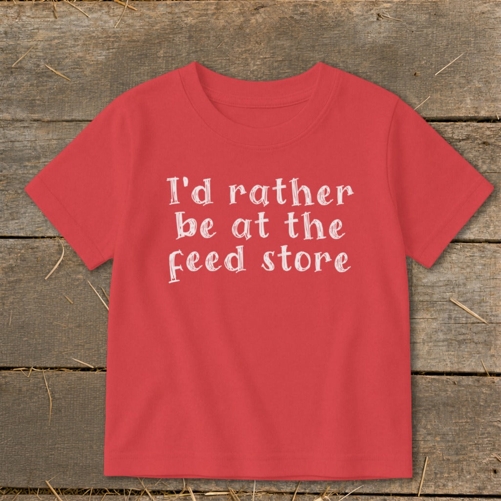 Red t-shirt with white text "I'd rather be at the feed store".