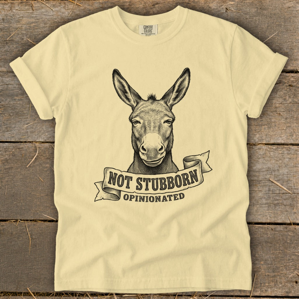 Light yellow t-shirt with black ink drawing of a donkey head and text "NOT STUBBORN OPINIONATED".