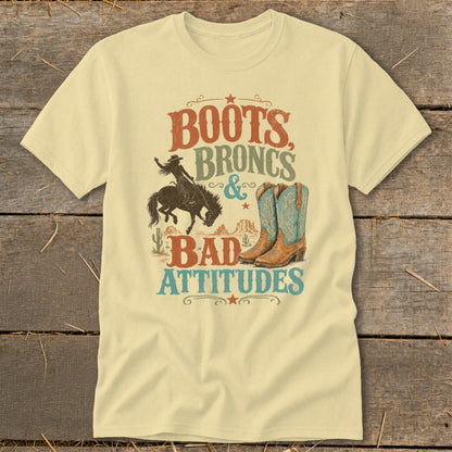T-shirt graphic with text "Boots, Broncs & Bad Attitudes," cowboy, and boots.