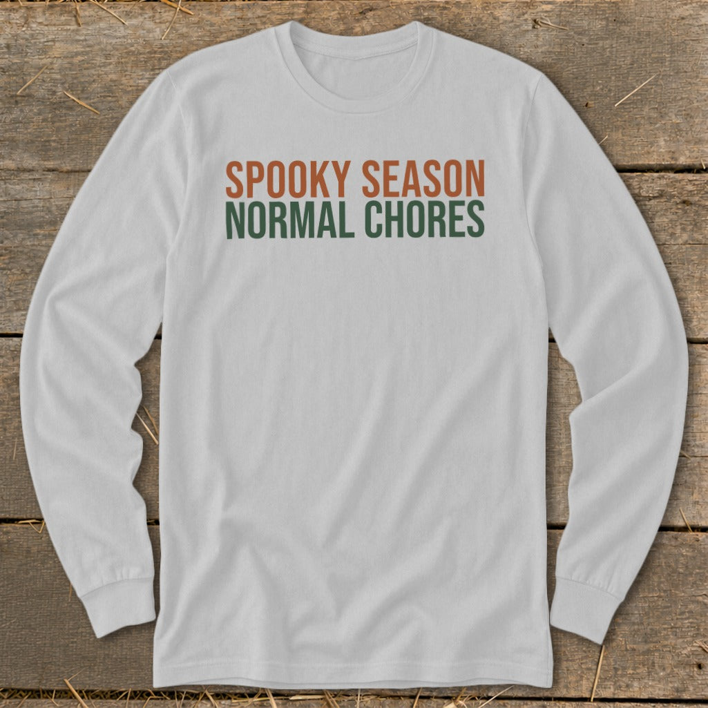 White long-sleeve shirt with text "SPOOKY SEASON NORMAL CHORES".