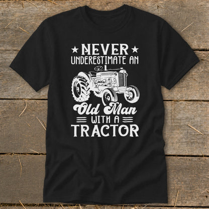 Black t-shirt with white text and tractor graphic: "Never Underestimate An Old Man With A Tractor".