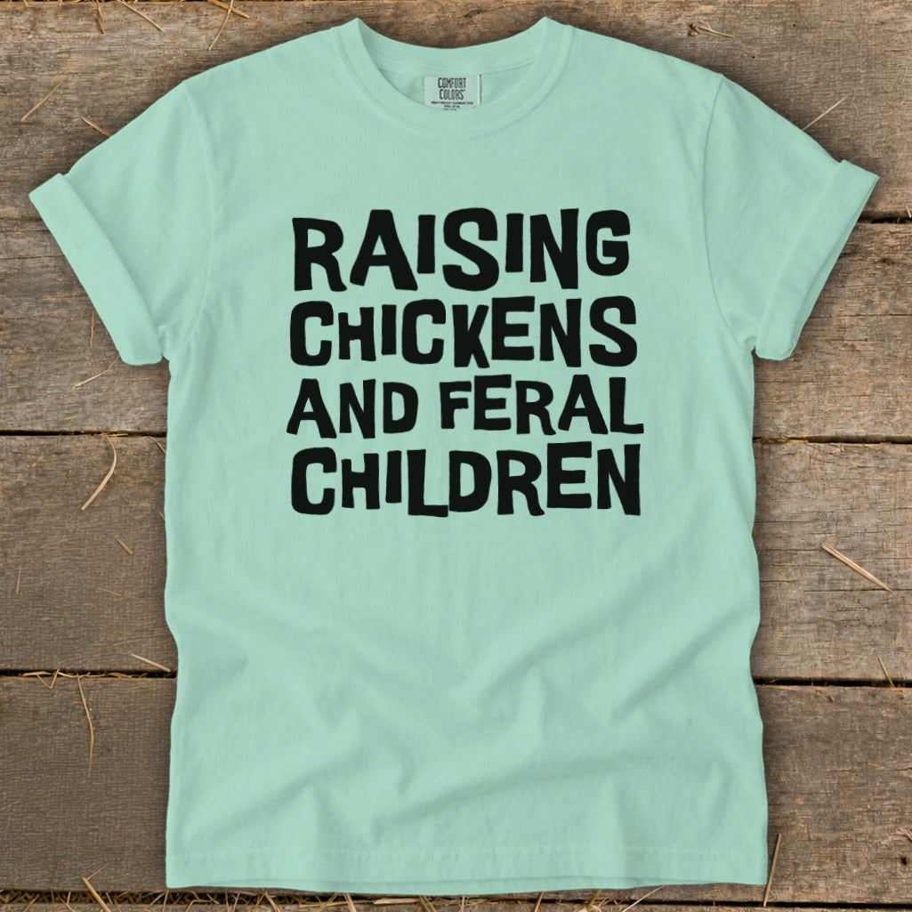 Mint green t-shirt with black text: Raising Chickens and Feral Children.