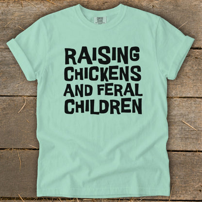 Mint green t-shirt with black text: Raising Chickens and Feral Children.