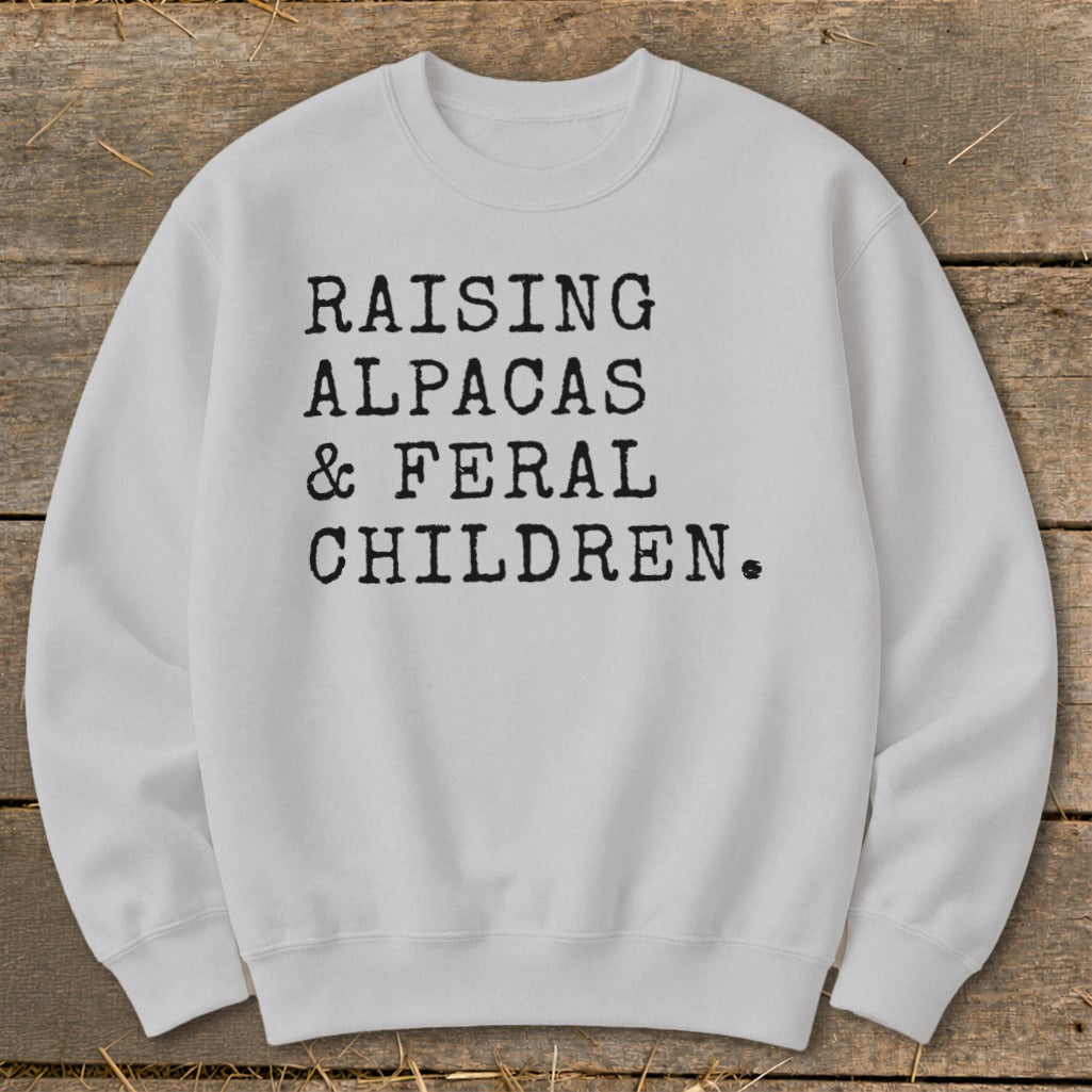 Light gray sweatshirt with black text: Raising Alpacas & Feral Children.