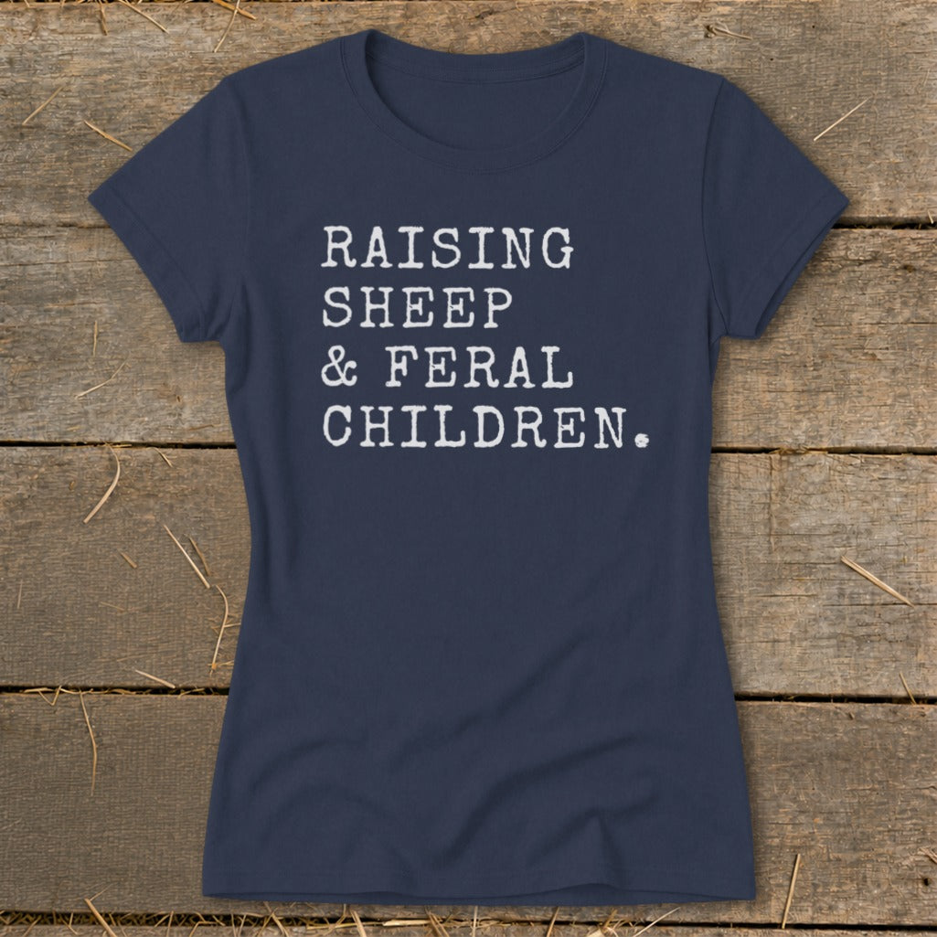 Navy t-shirt with white text reading "RAISING SHEEP & FERAL CHILDREN."