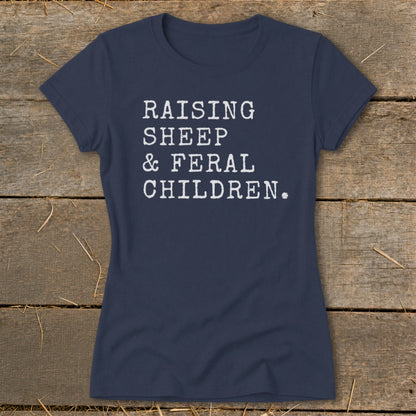 Navy t-shirt with white text reading "RAISING SHEEP & FERAL CHILDREN."